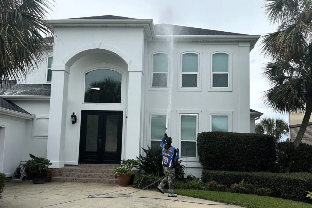 man soft washing a roof